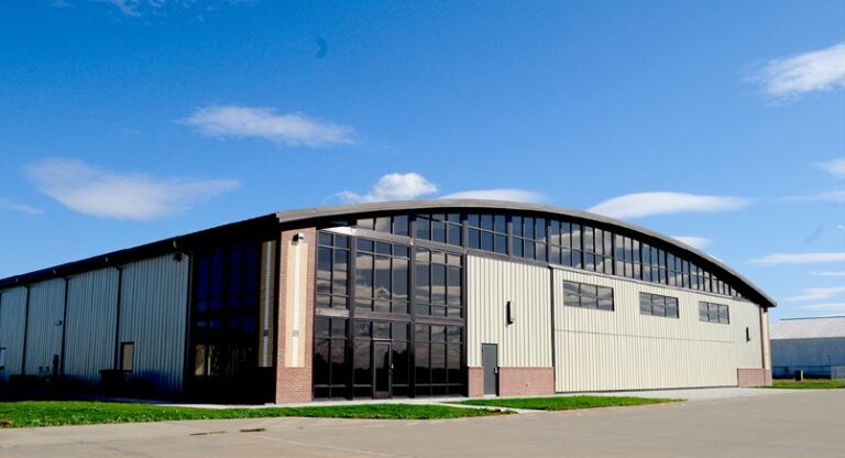 Airplane hangar on a bright day with a few clouds
