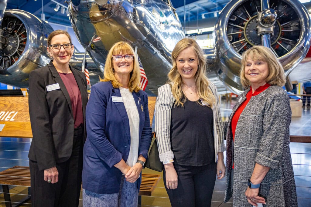 Women standing in front of plane.