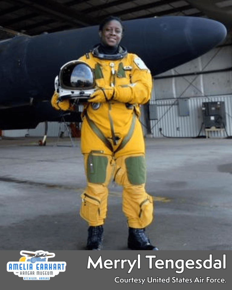 Merryl Tengesdal in yellow flight suit holding her helmet